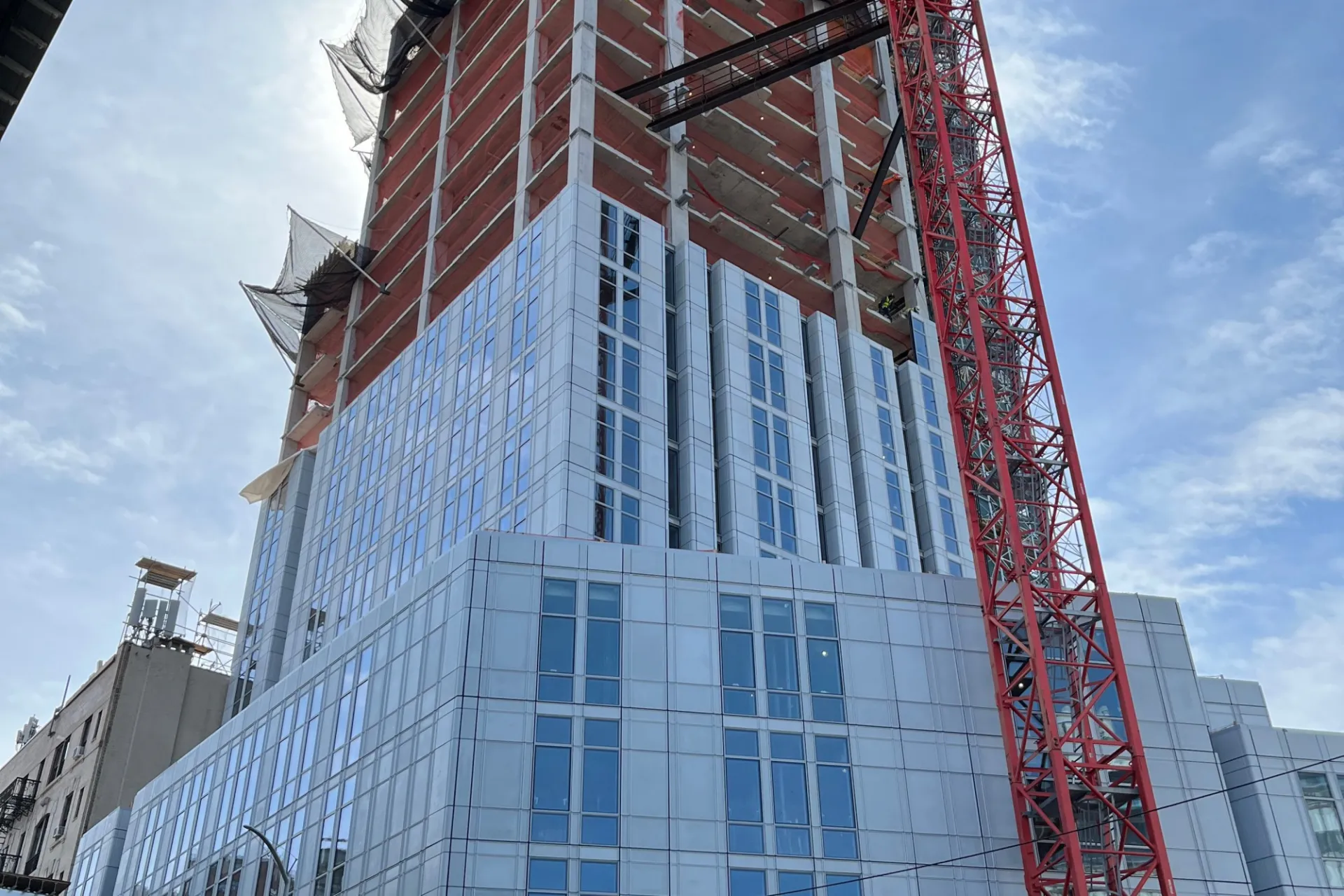 A view of the 600 W. 125th Street construction site near the street level, which has facade panels installed around it. 