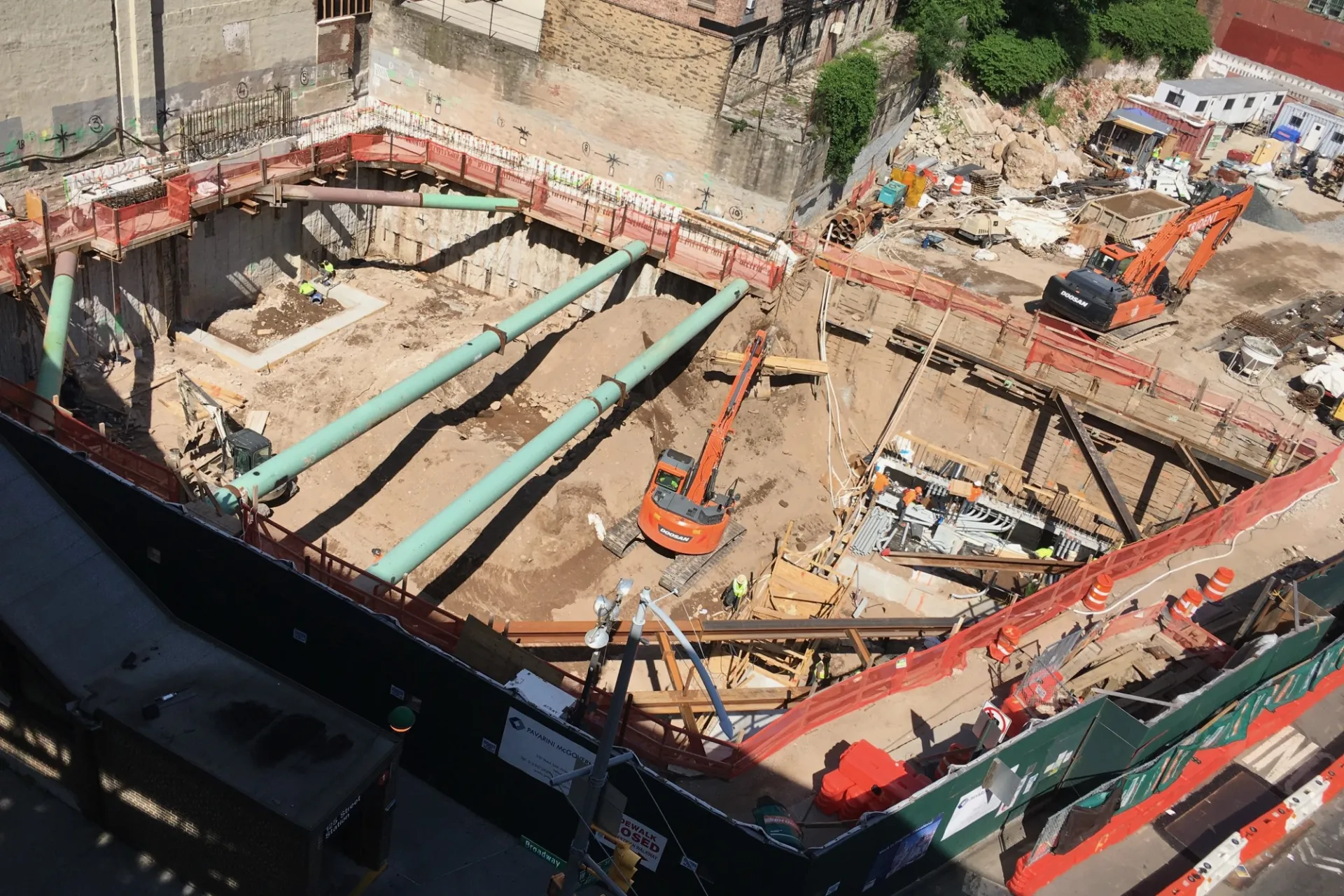 A view of the 600 W. 125th Street construction site with steel beams running across a dirt pit. 