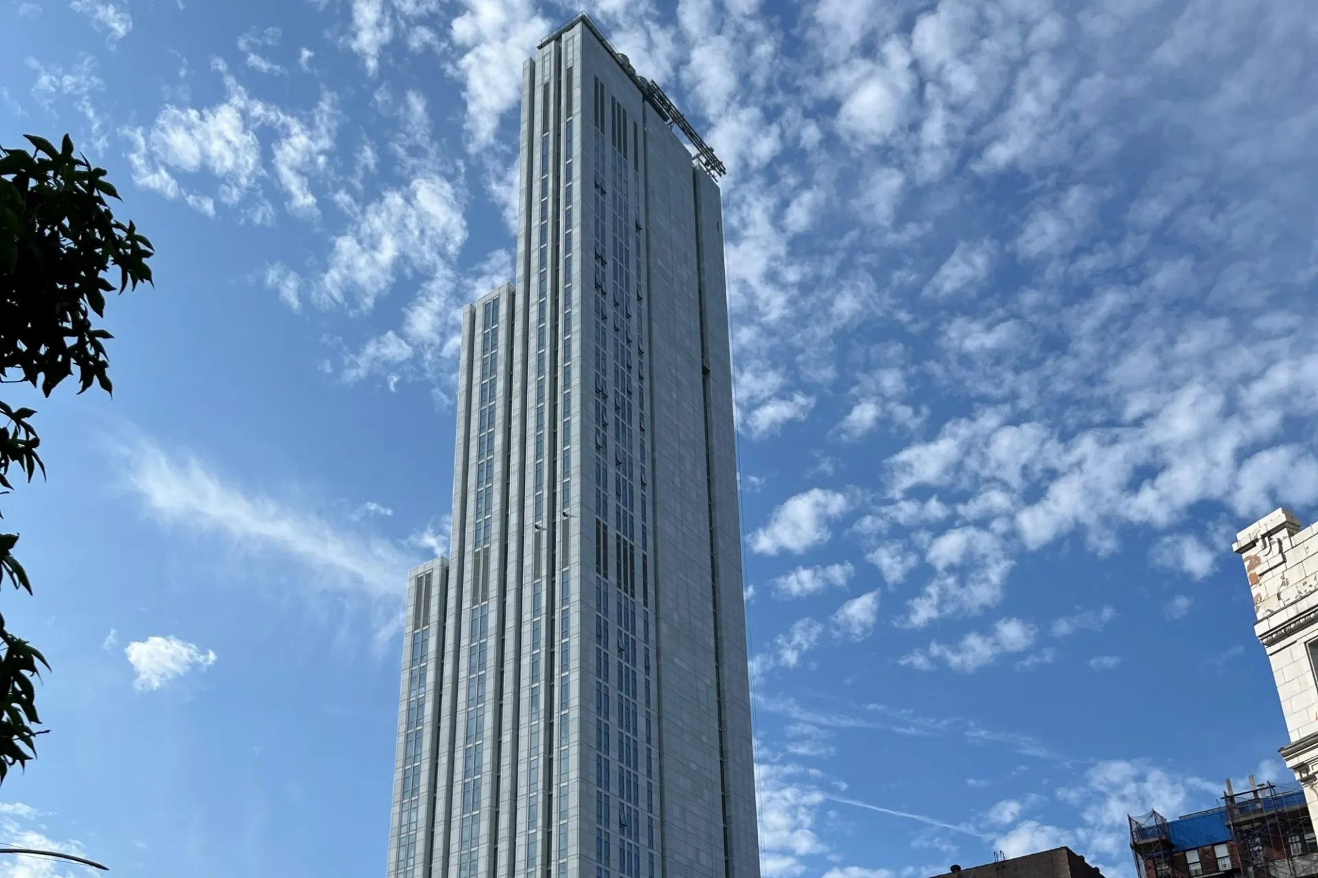 A view of the upper floors of 600 W. 125th Street, looking southeast, on a partly cloudy day.