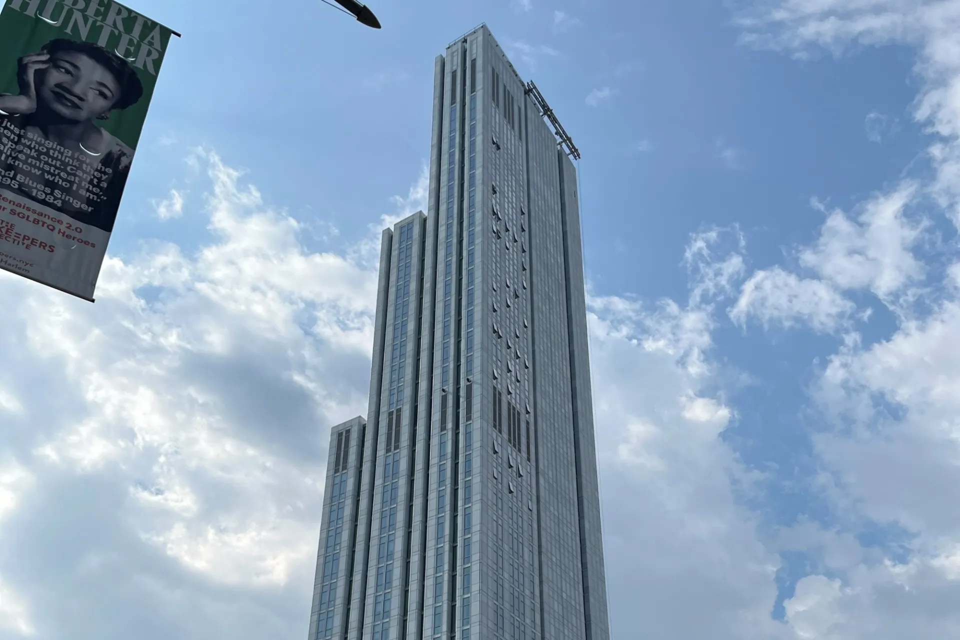 A view of the upper floors of 600 W. 125th Street, looking southeast, on a partly cloudy day. 