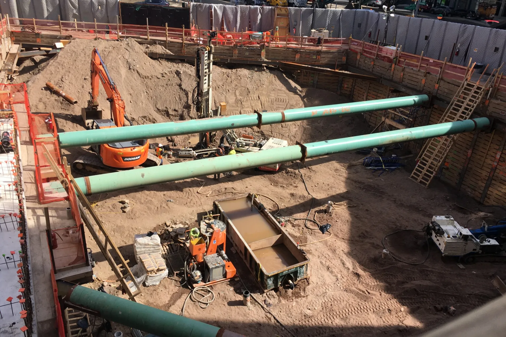 A view of the 600 W. 125th Street construction site with equipment and support pipes running across. Foundation work being performed on a construction site.  