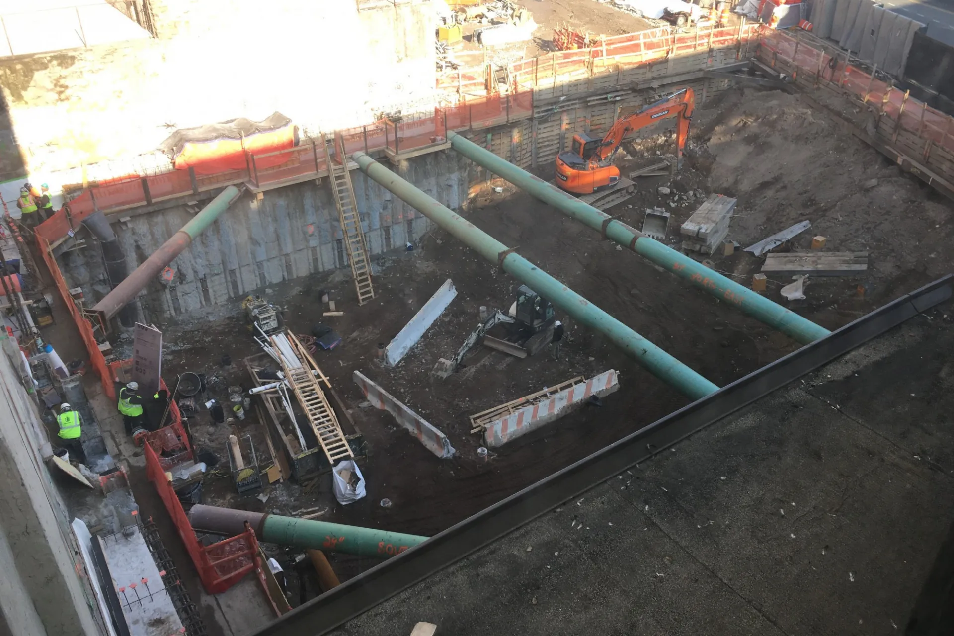 A view of the 600 W. 125th Street construction site with equipment and support pipes running across. Foundation work being performed on a construction site. 