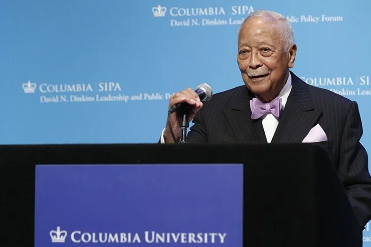David Dinkins speaking in front of blue screen. 