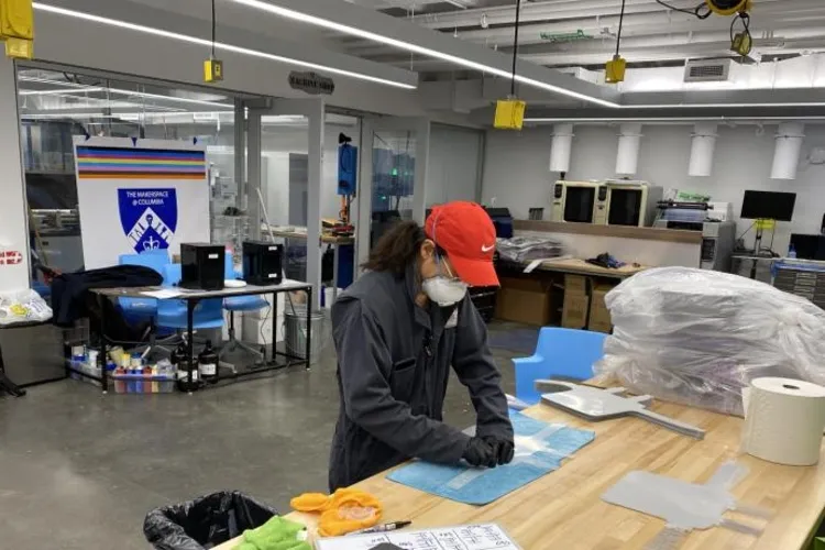 A woman in a factoring assembling a face mask.