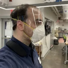 A man wearing a mask and a face shield 