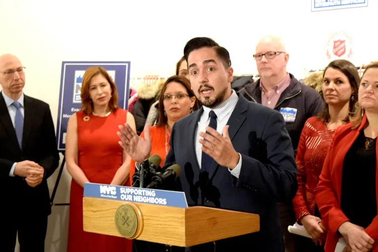 Frankie Miranda speaking with a group of people behind him.
