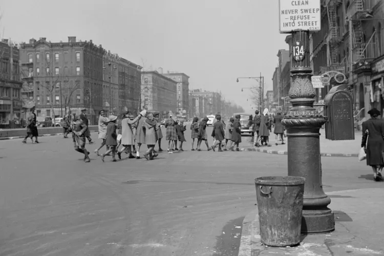 A group of children walk across a street in Harlem. 