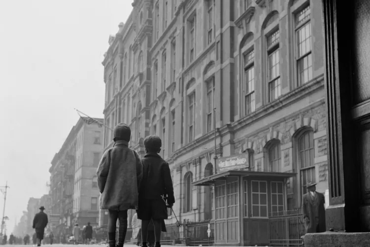 Two children look up at building in Harlem in the 1940s.
