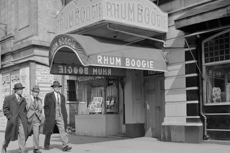 Three men walk by the "RhumBoogie" club in Harlem. 