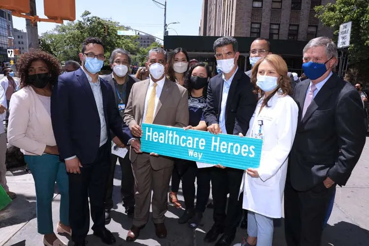 group of people posing for photo with street sign