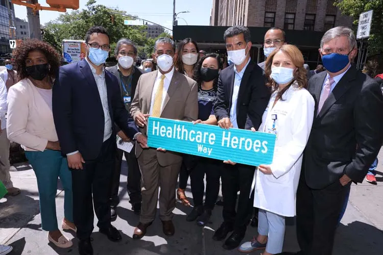 group of people posing for photo with street sign