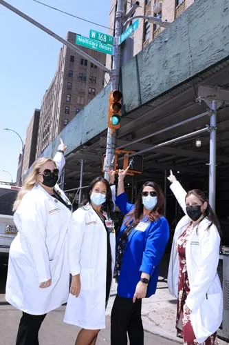 Street corner sign with group of people pointing at it