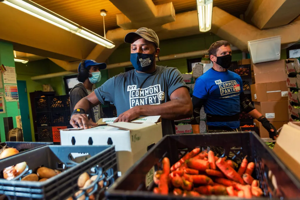 A group of volunteers opening pantry boxes. 