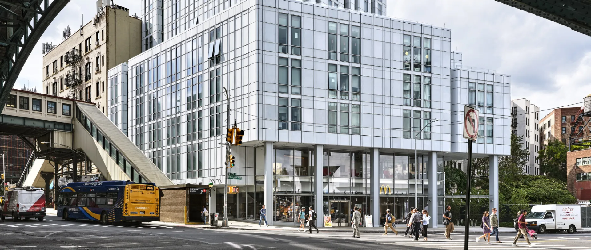 A view of 600 W. 125th Street from across the street with the overhead 1 train bridge visible.