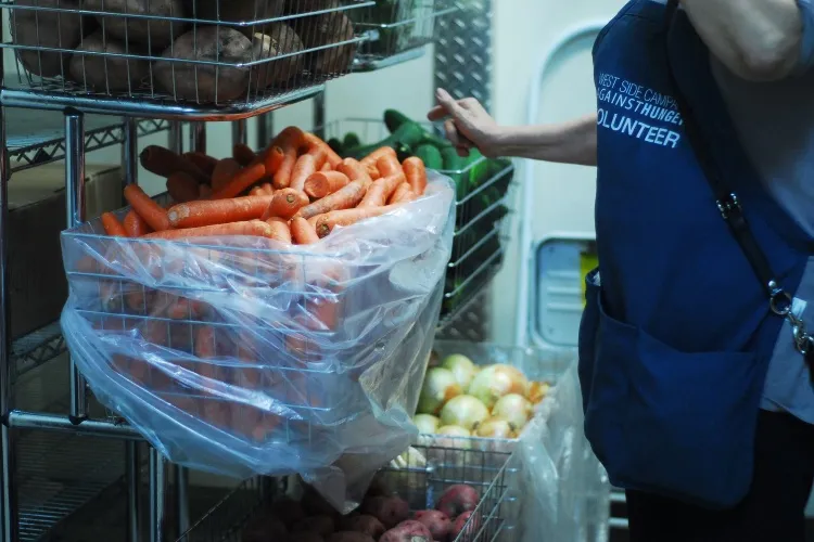 produce and a volunteer bagging the produce.