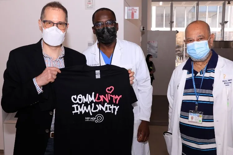 The team behind Community Immunity holds a shirt