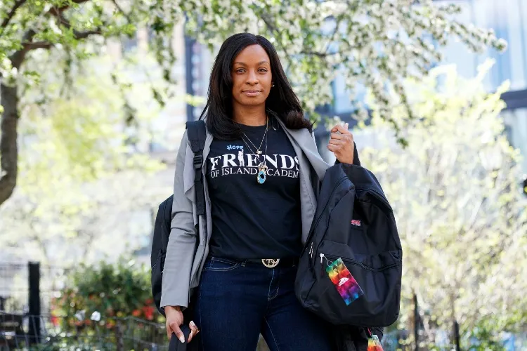 Woman with a backpack standing in a park during the day