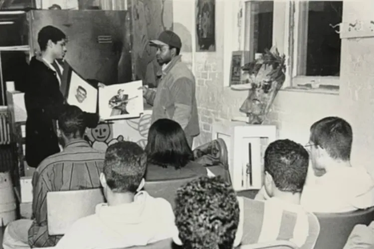 José Ortiz and his painting instructor, Leonard Jenkins, sharing a college portfolio with students at the Art Carnival in 1994. Photo credit: José Ortiz
