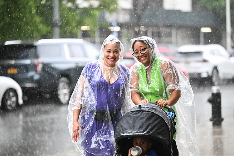 Two smiling attendees in rain ponchos as it poured.