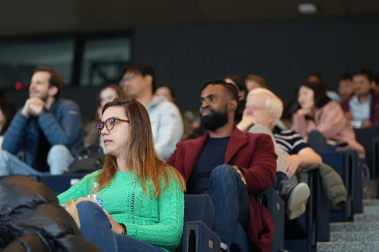 A group of people watching a lecture.
